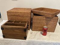 Photo showing two wicker boxes with lids and one wooden box with compartments. Coca-Cola can placed for size reference.