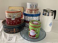 Photo of seven assorted decorative cake tins, including Christmas-themed and floral designs