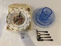Royal Doulton Bunnykins clock alongside vintage childs cutlery and blue glass dish set.