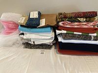 Stack of assorted fabric pieces showing variety of colors, textures, and patterns including sheer, solid, and printed materials.