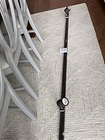 Track light fixture laid out on carpet with two attached adjustable light heads, black metal finish, 74 inches long.