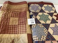 Two quilts folded side by side showing star block and square/star block patterns in plaids and solids