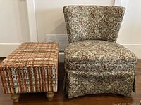 Front view of vintage floral upholstered chair with matching footstool.