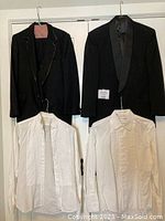 Two black dinner jackets with satin trims and three white dress shirts on hangers