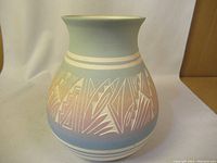 Front view of the ceramic vase showing the bulbous body, flared rim, and geometric decorative pattern in pastel colors.
