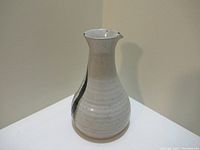Front and side view of the light gray ceramic vase with a narrow neck and black drip design on the side.