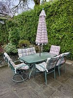 Full view of the patio set showing table, chairs with cushions, and umbrella in closed position.