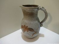 Front view of the ceramic jug showing floral design and handle shape.