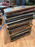 Stack of assorted vinyl record albums showing spines and some cover titles related to classical music.