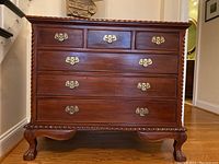 Front view of dresser showing all drawers, carved trim and brass pulls
