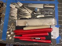 Overview of forks, decorative spoons, serving pieces and candles laid on table