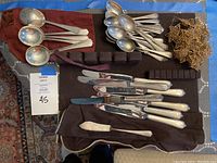 Overview of all sterling silver utensils laid out with gold star garland