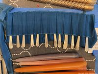 Blue fabric roll holding multiple butter knives
