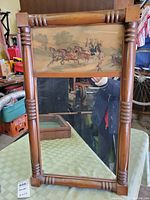 Front view of the full antique mirror showing the wood frame and inlay print as well as the reflective mirror surface.