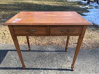 Full view of the wooden table showing two drawers and overall condition