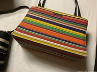 Multicolor striped Kate Spade purse showing base and fabric pattern