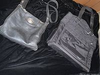 Two bags placed on black fabric background, Fossil leather cross body and black Lug tote bag