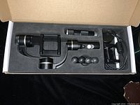 Open box showing the G4 Pro gimbal stabilizer with accessories including charging cable and mounting parts