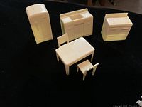 Image showing four ivory plastic miniature furniture pieces: refrigerator, kitchen cabinet, stove, dining table with two chairs.