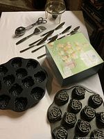 Photo showing the set of 8 spreaders, a large fork, salad tongs, and two rose-shaped Nordic Ware muffin pans.