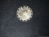 Back of brooch showing sterling silver stamp and hinged pin clasp.