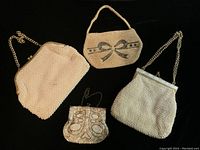 Four vintage evening bags arranged on black backdrop showing varied styles and materials including beads and sequins.