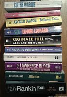 Stack of 10 mystery paperback novels showing titles and author names on spines.