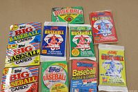 Overview of all 10 unopened baseball card wax and cellophane packs from late 1980s, showing multiple manufacturers and colorful packaging.