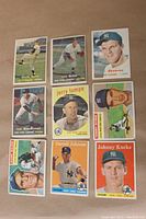 Nine New York Yankees baseball cards arranged in three rows of three on a flat surface. Cards show various players in action and posed shots dating from 1956 to 1959.