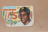 Front of the 1956 Roberto Clemente baseball card showing the player photo and nameplate with damage.