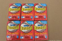 Top front view showing six unopened 1988 Donruss Junior Baseball wax packs arranged in two rows of three, prominently displaying the red, white, and blue colorful packaging and the text indicating 15 cards and 3 puzzle pieces each.