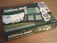 Photo of the unopened Double Screen Talking Golf electronic handheld game in original box showing front and top with golf course background graphics and the game device depicted.