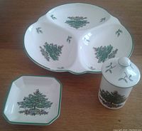 Sets of Spode Christmas Tree porcelain pieces showing the 3-section relish dish, small square plate, and the small cup with lid arranged on a flat surface.