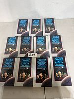 Front view showing 11 Star Trek The Next Generation VHS tapes in plastic cases with artwork featuring the main characters and planet background.