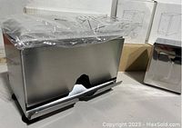 Close-up photo showing one stainless steel straw dispenser with a cutout opening at the front.