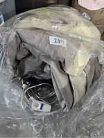 Folded grey Aerobed queen air mattress in plastic packaging with attached white electric pump remote control with power cord.