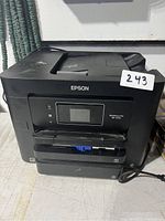 Front view of the Epson WorkForce Pro printer showing the control panel and paper trays.