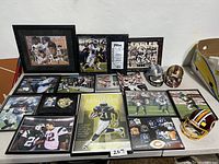 Overall view of framed NFL photos and three mini football helmets on table