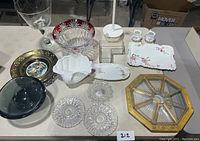 Full collection of glass and ceramic bowls, plates, and serving pieces on display, showing variety and condition.