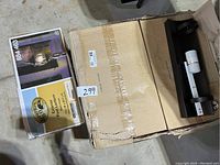 Three boxes containing Hampton Bay exterior post lanterns and an opened box showing one post lantern fixture inside.