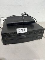 Sony CDP-C322M 5-disc CD player with Samsung BD-JM57C Blu-ray player stacked on top, both with attached power cables.