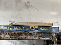 Boxes of Super Coach's TV Football, Do You Remember Husker Du? memory game, and NFL Conference game stacked showing titles and box wear