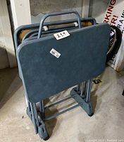 Three folded vintage snack tables stacked together with visible metal folding legs and blue laminate tops