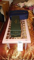 Green Dom Perignon champagne bottle box with gold lettering and heart emblem, placed on a white metal surface alongside a blue fabric carrying bag.