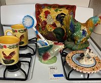 Full view of the collection showing mugs, plates, figurines, and brush holder all with rooster theme.