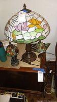 Photo showing the three Tiffany-style table lamps with stained glass shades in floral patterns and metal bases.
