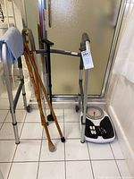 Walker, five wooden canes, and Health-o-Meter scale shown together in bathroom setup.