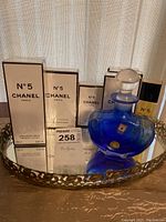 Group shot of Chanel N°5 boxed products, mini bottles, and blue decanter on tray