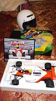 Full overview showing helmet, model car in styrofoam tray, Hot Wheels cars and box art