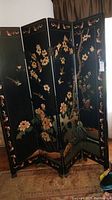 Full front view of six-panel black lacquer folding screen with hummingbird and floral motifs